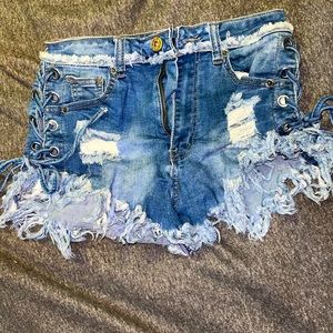 Stretchy distressed denim shorts. Lace up sides.